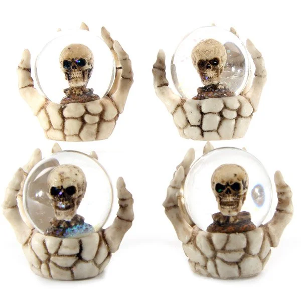Skeleton hand snow globe featuring a skull inside crystal glass, resin body