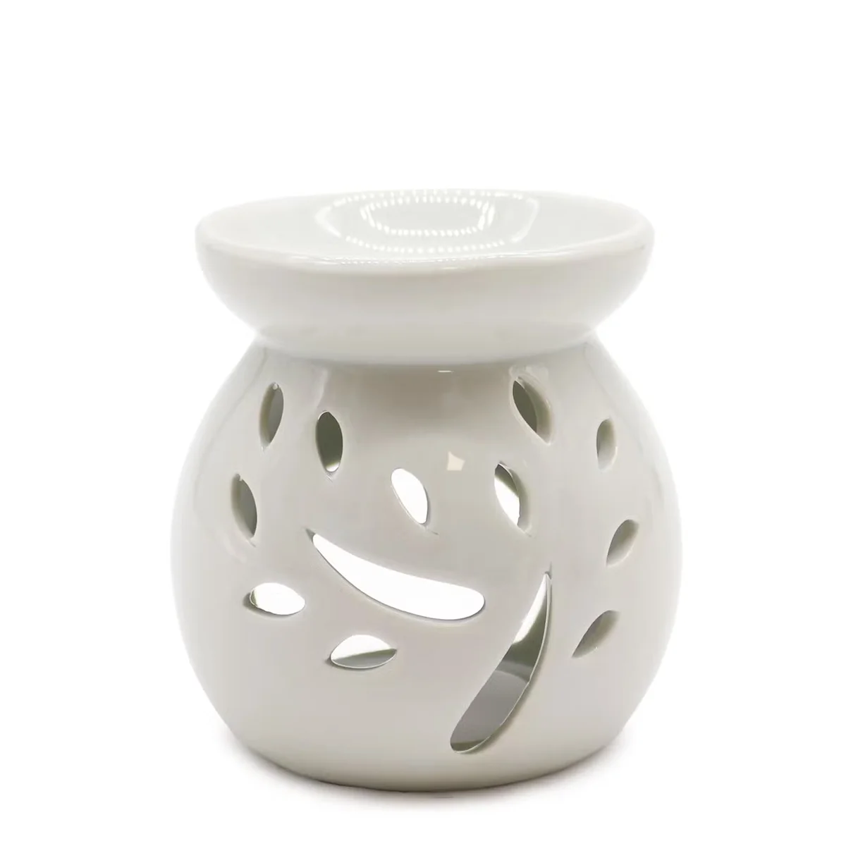 White oil burner ornament with a carved tree cut-out design
