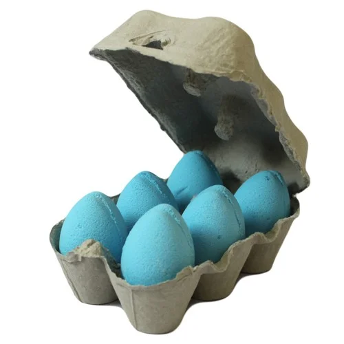 Blueberry bath bomb eggs displayed in a wooden tray.