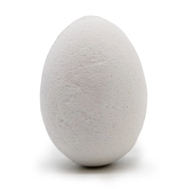 Coconut bath eggs arranged neatly in a tray on a bathroom shelf.