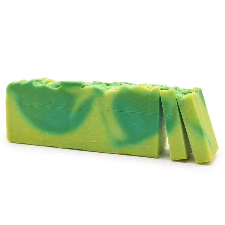 Aloe vera soap loaf made with olive oil, displayed on a wooden cutting board.