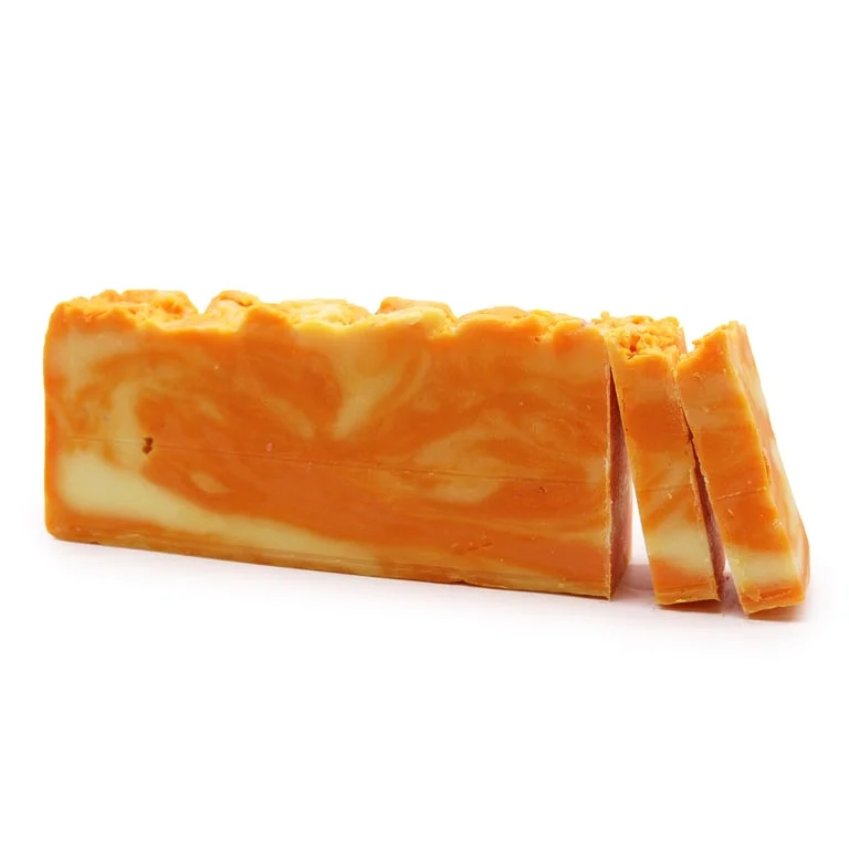 Loaf of orange olive oil soap with bright orange strips and a natural olive oil scent.