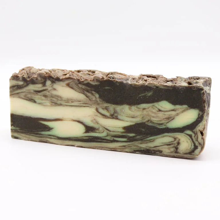 Cinnamon soap loaf, brown loaf with cinnamon threads, on wooden surface.