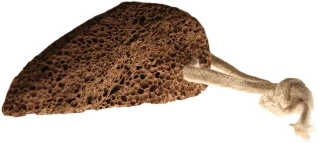 Volcanic foot stone in its traditional shape on a plain background