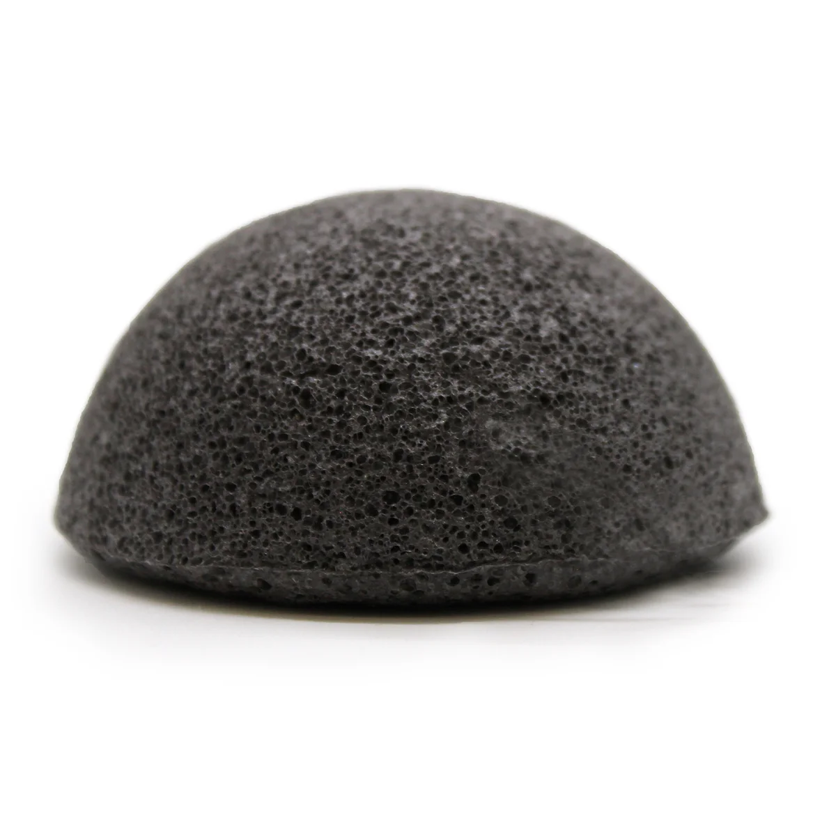 Charcoal cleaning sponge made from konjac plant, natural textured sponge with muted charcoal color for gentle exfoliation.