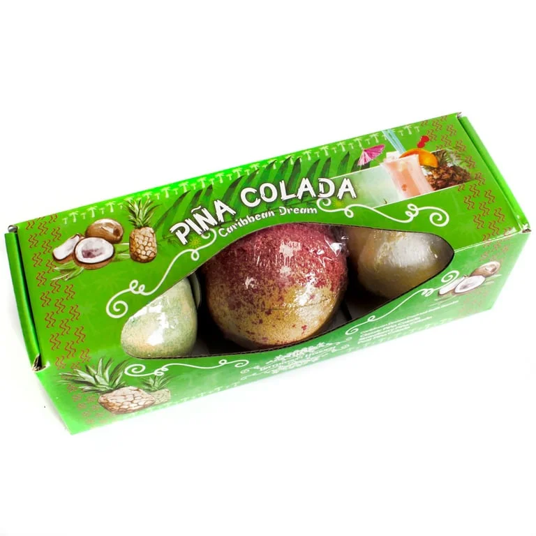 Three piña colada bath bombs arranged in a clear glass display.
