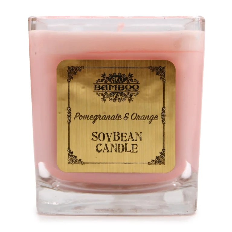 Soy candle scented with pomegranate and orange, showing translucent clear wax in a simple white jar.