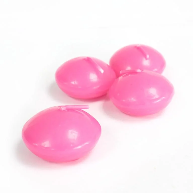 Small pink floating candle resting on a glass surface.