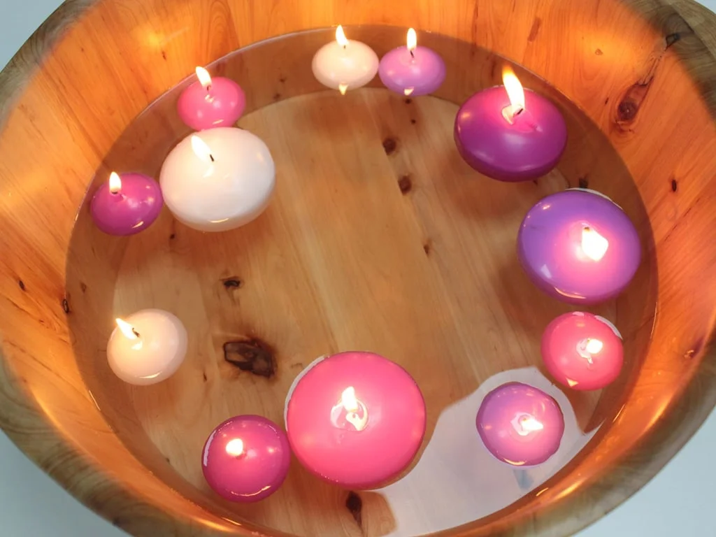 Pink small floating candle shown on a smooth surface.