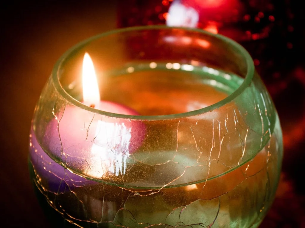 Small floating candle pink resting in clear water, creates calming glow.