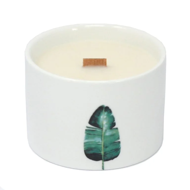 A med botanical candle scented with lemon honeysuckle, gently glowing.