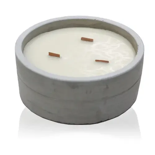 Large round crushed vanilla candle with orange accents.