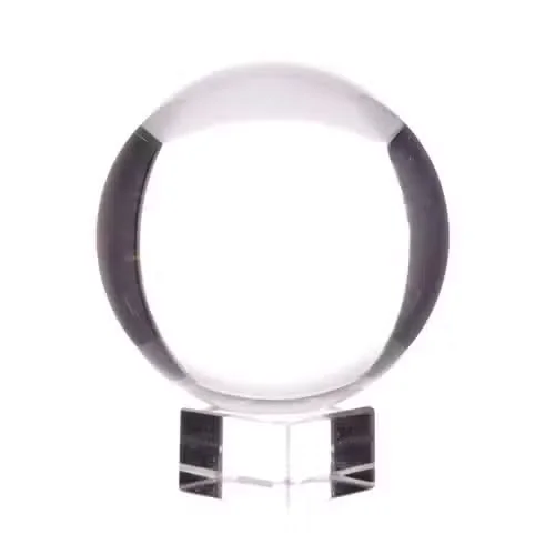 100mm crystal ball sits on a simple wooden stand, clear sphere against light background.