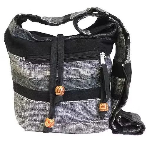 Nepal sling bag in mountain granite color displayed on a shoulder, featuring a zipper and adjustable strap.