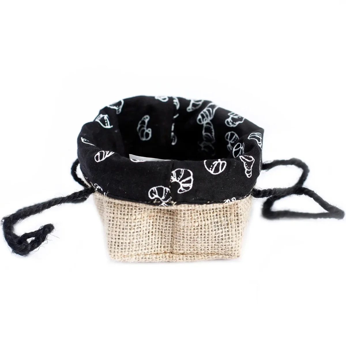 Small jute gift bag with natural jute exterior, black lining, open front, held by hand.