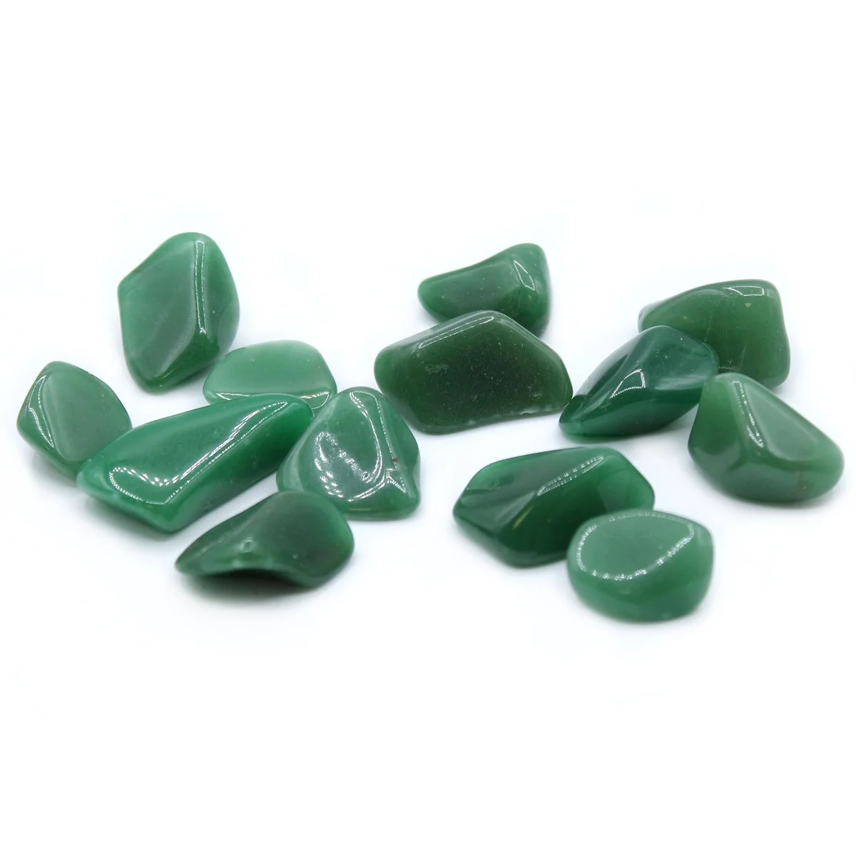 Group of green quartz tumble stones laid out on a flat surface