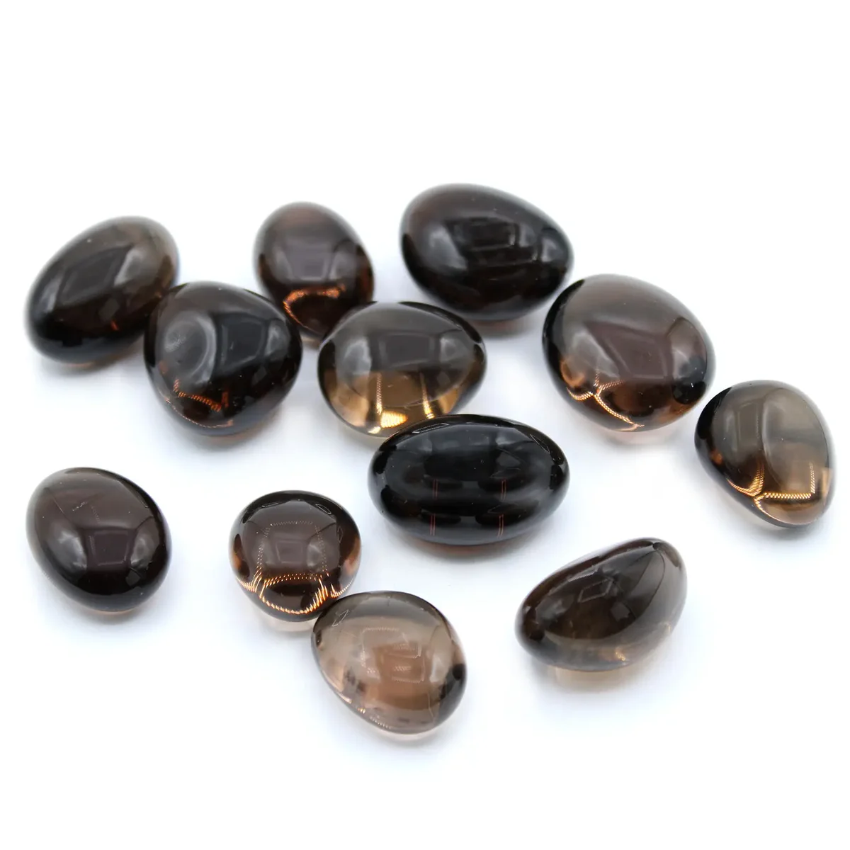 Assorted natural smoky quartz stones displayed on a flat surface.