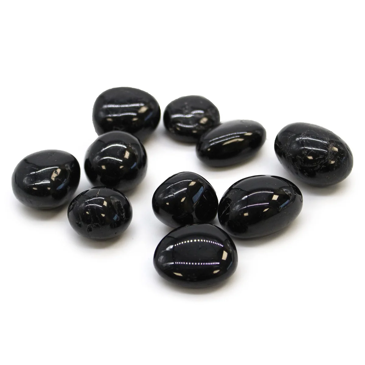 Black tourmaline tumble stones displayed in a clear container.