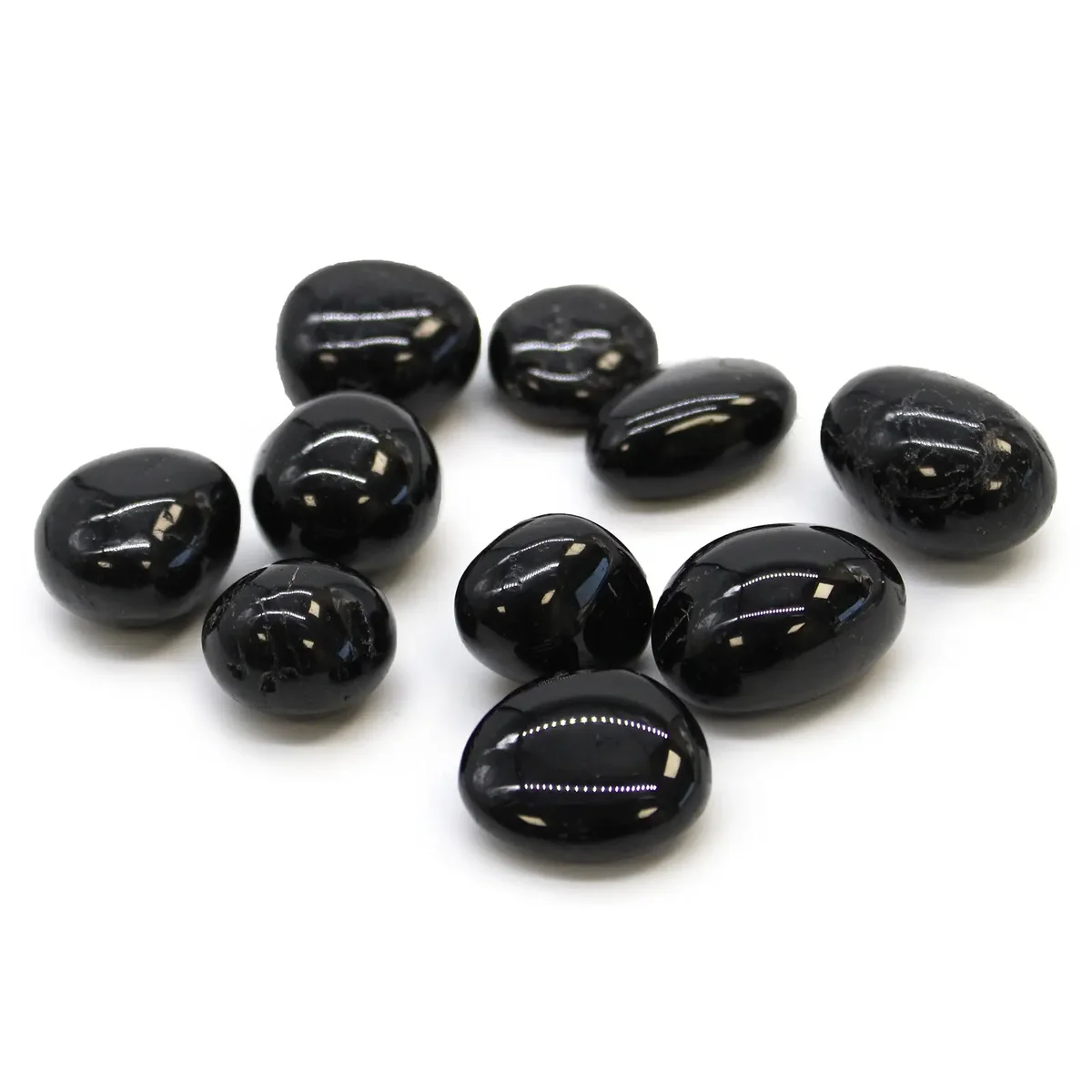 Smooth black tourmaline stones arranged in a tumbling crystal display.