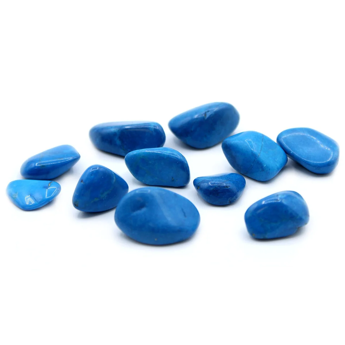 Blue howlite tumble stone on neutral background, showing its smooth, iridescent surface.