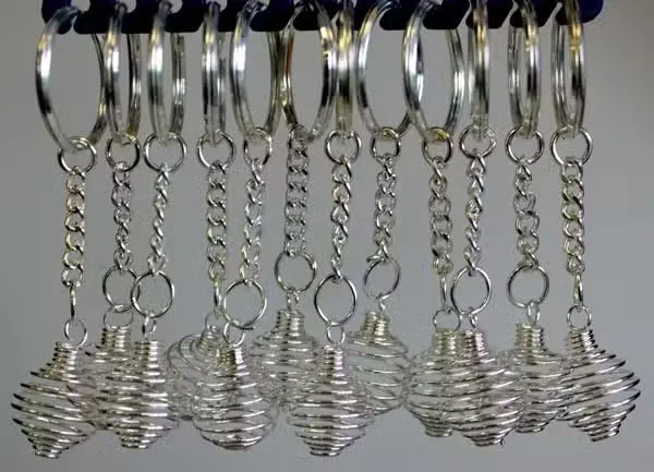 12 spiral keyrings displayed together, showing metallic spiral cage shapes.