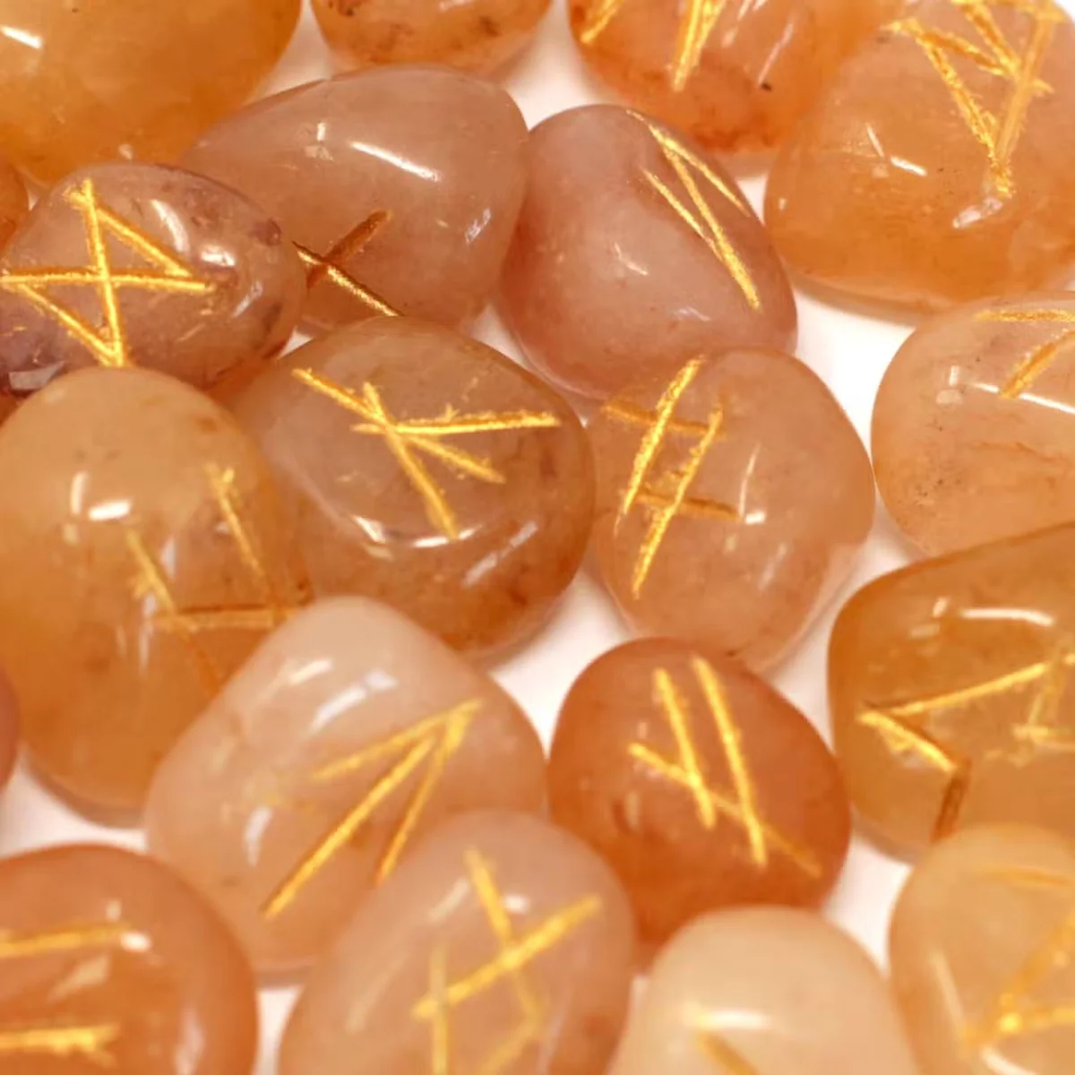 Spiritual stone set in a pouch featuring yellow aventurine stones etched with rune designs, on a dark background.