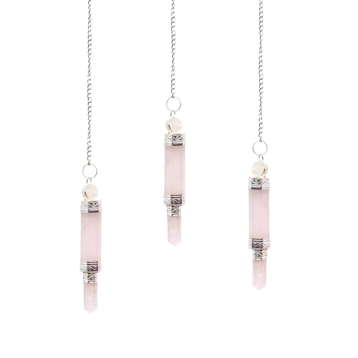 Spiritual pendulum of rose quartz hanging in mid-air.