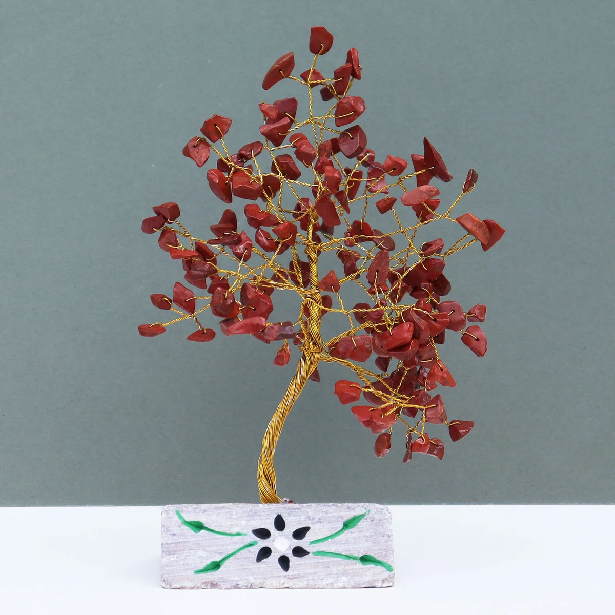 Natural jasper ornament in rich red stone, showing textured surface and subtle shine