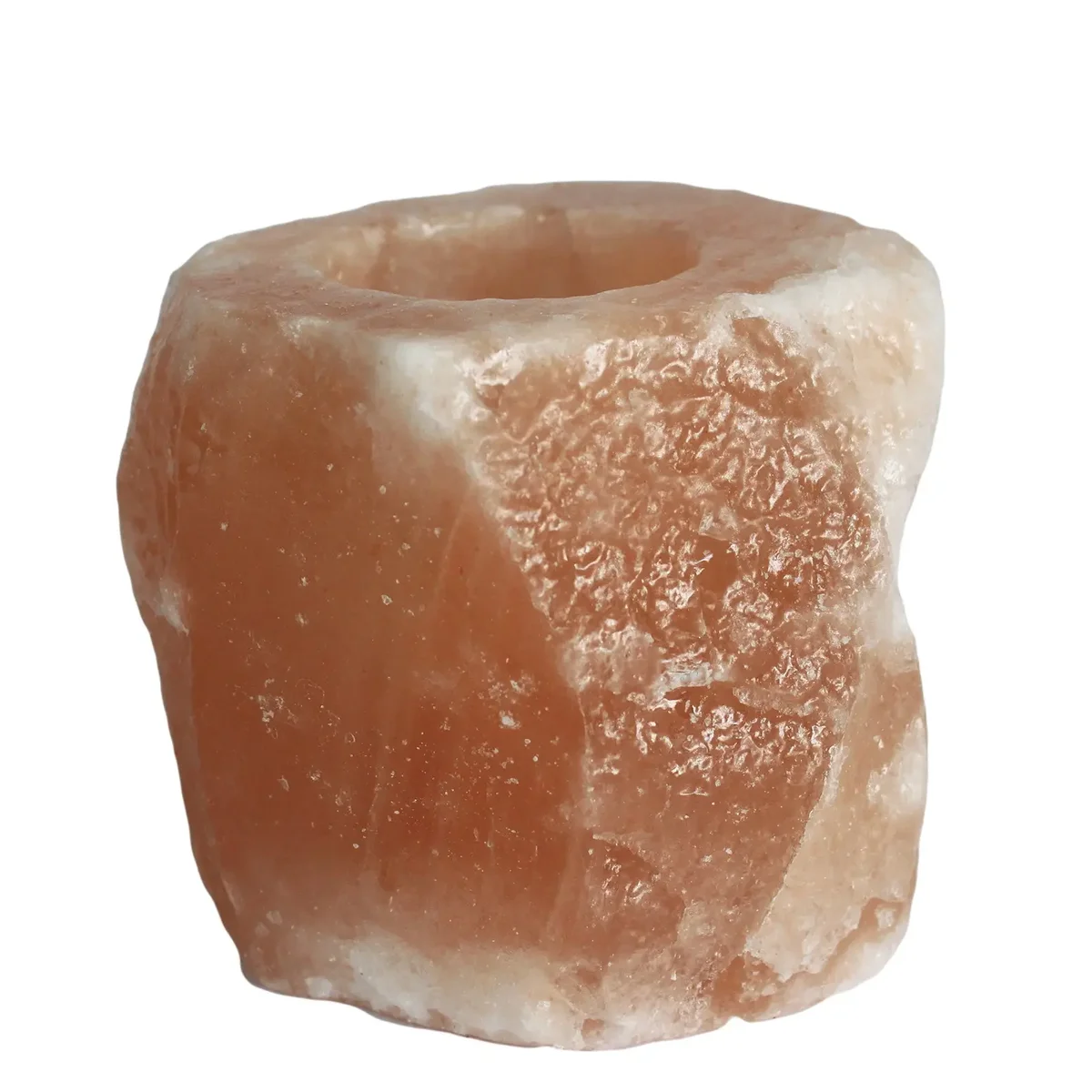 Natural salt holder displaying a lit candle atop a salt block in a simple setting.