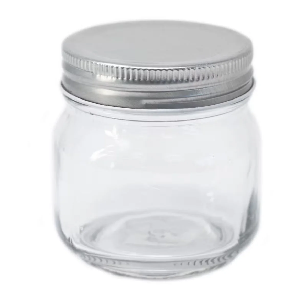 Square jar with lid sitting on a white surface.