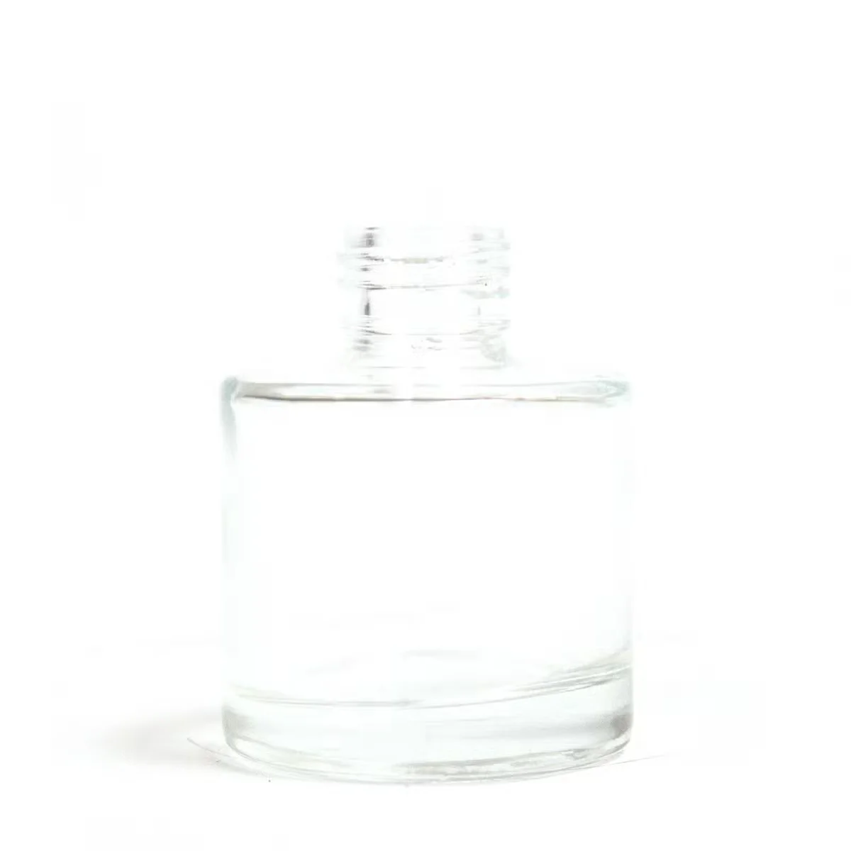 Clear 50 ml round reed diffuser container shown empty on a white background, highlighting its smooth glass surface