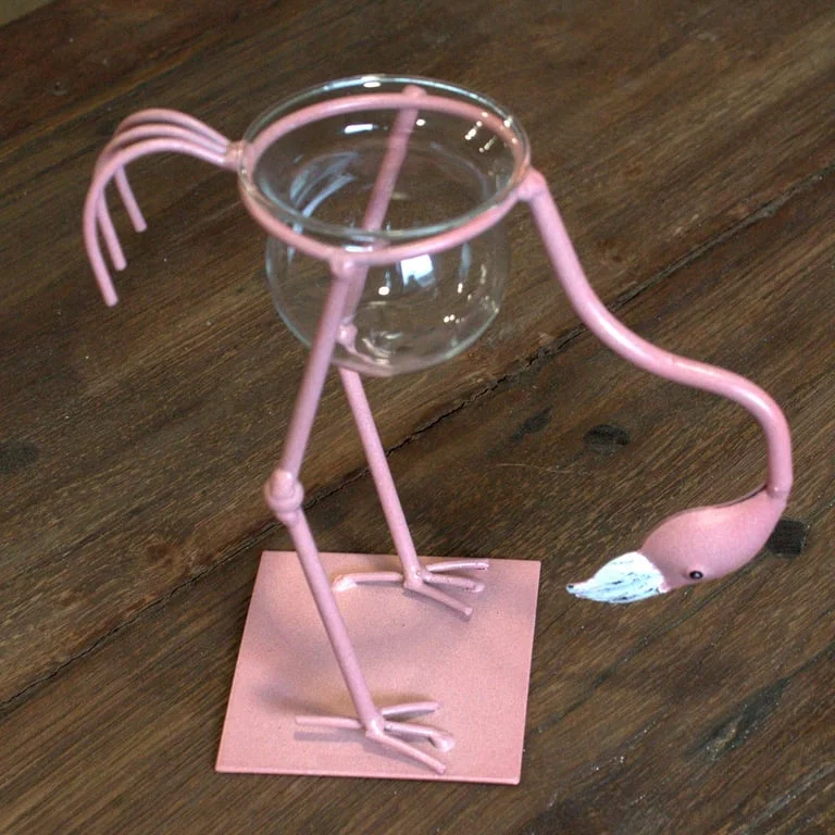Pink metal flamingo décor on a neutral background.