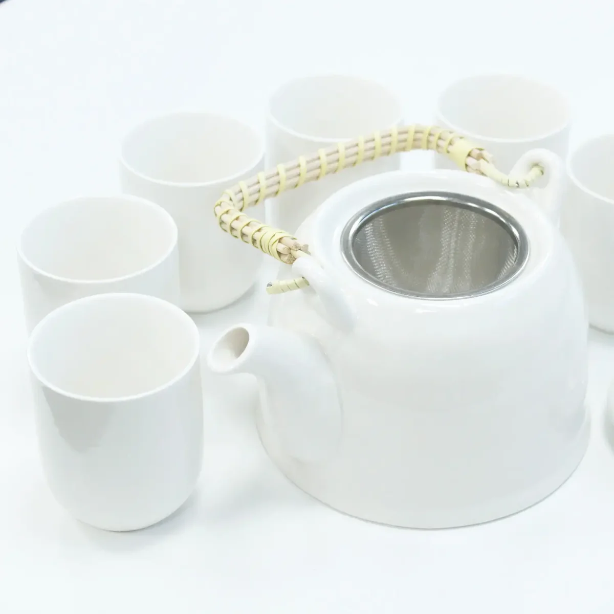 Classic white herbal tea set featuring a teapot and matching cup in a minimalist design.