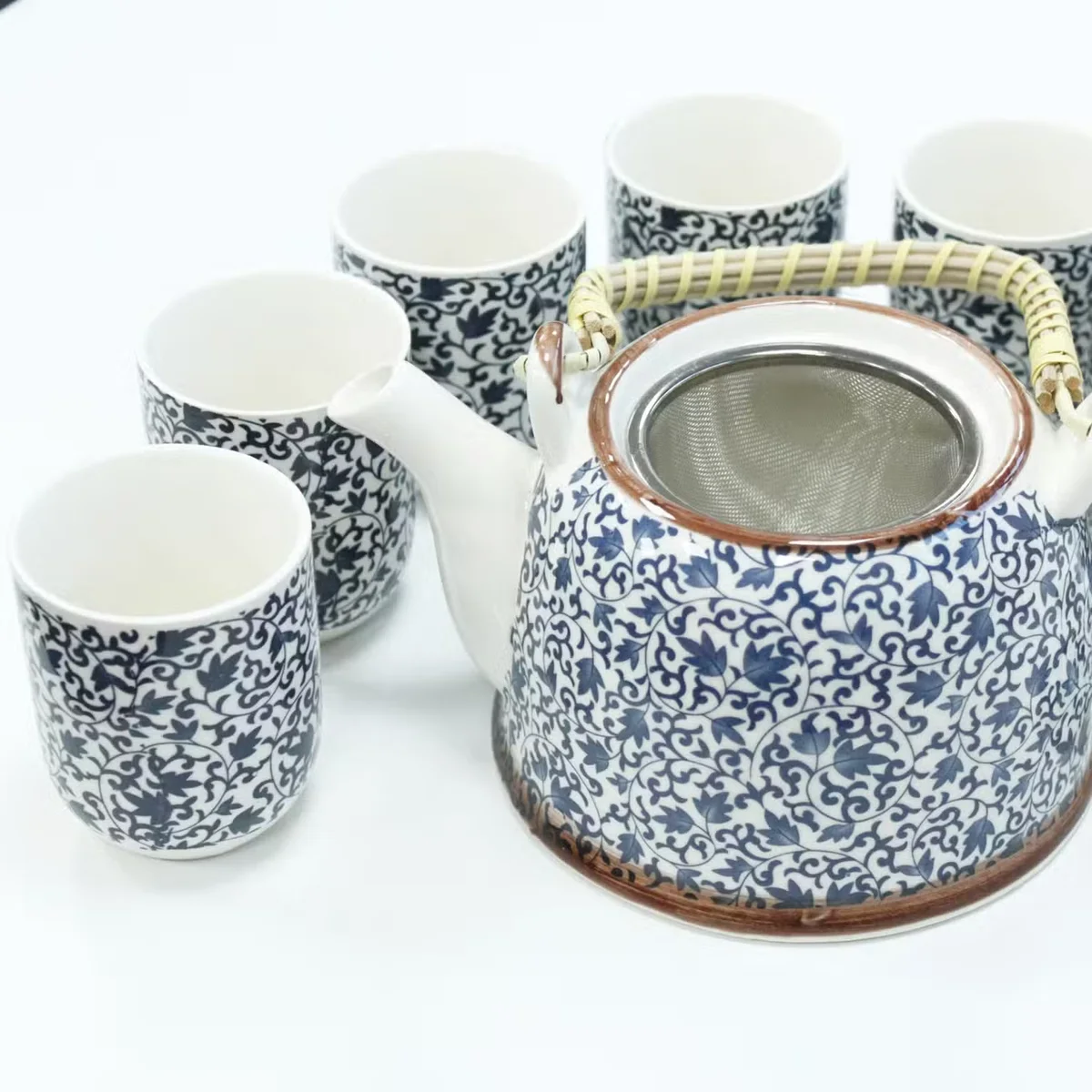 Blue patterned ceramic teapot set with matching cups and tray displayed on a wooden surface