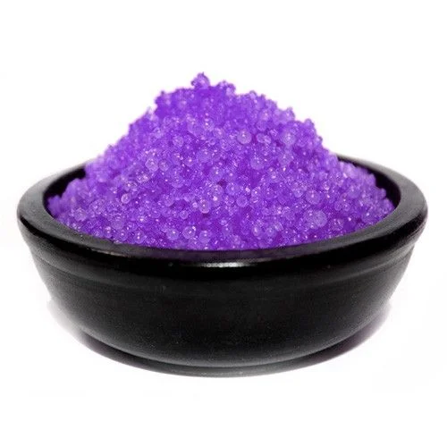 Small jar filled with purple lavender simmering granules on a white background