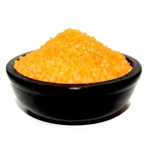 Cinnamon orange granules arranged on a white surface.