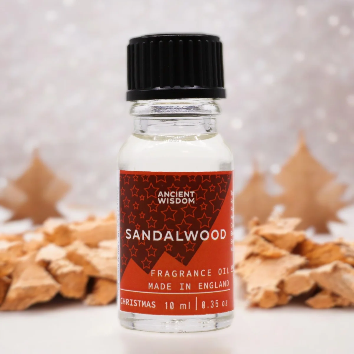 10ml bottle of Xmas sandalwood fragrance, dark amber liquid inside, label prominently displayed.