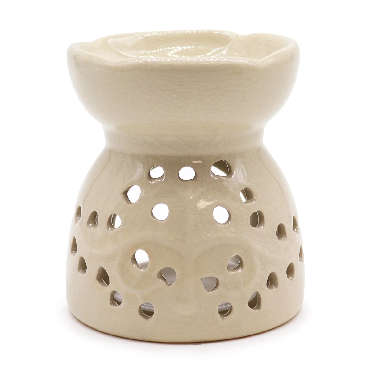 Tree of life oil burner in ivory, featuring carved tree silhouette, placed on a wooden surface.