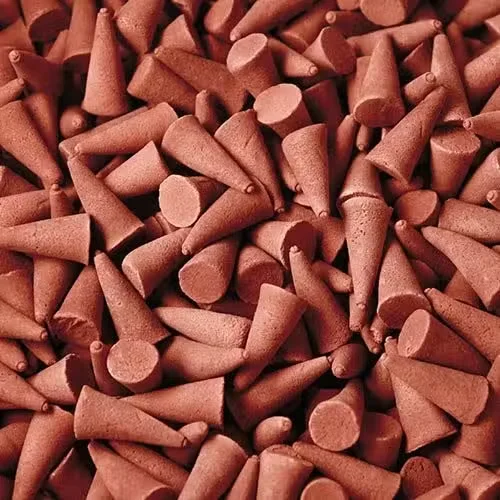 Gold incense cones arranged in bulk on a simple background.