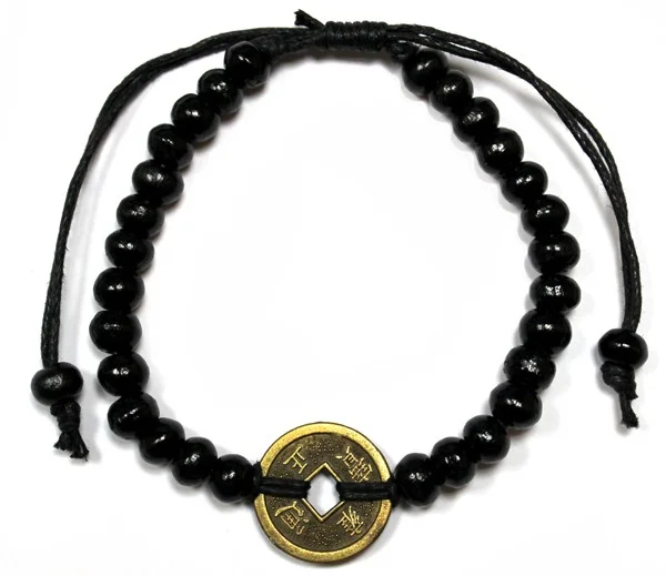 Black feng shui bracelet adorned with subtle charm, shown on a wrist.