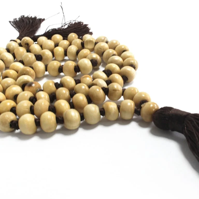 Brown Bali tassel wall hanging 70 cm, elegant fabric fringe draped against a neutral backdrop.