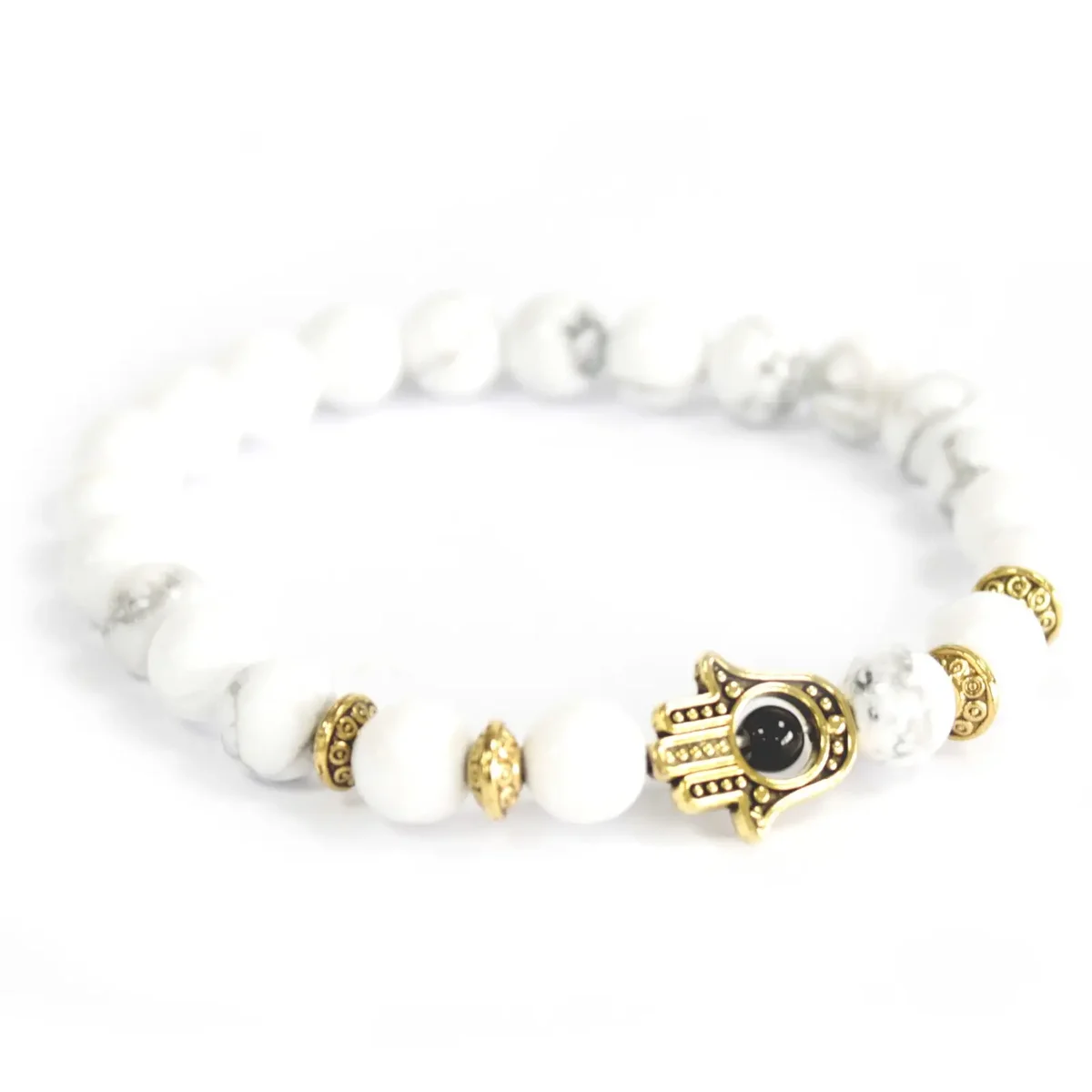 Gold Hamsa and white stone bracelet featuring a hand motif with sparkling white stone accents.
