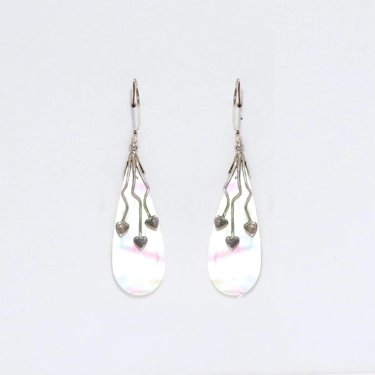 Three heart earrings made of shell and silver.