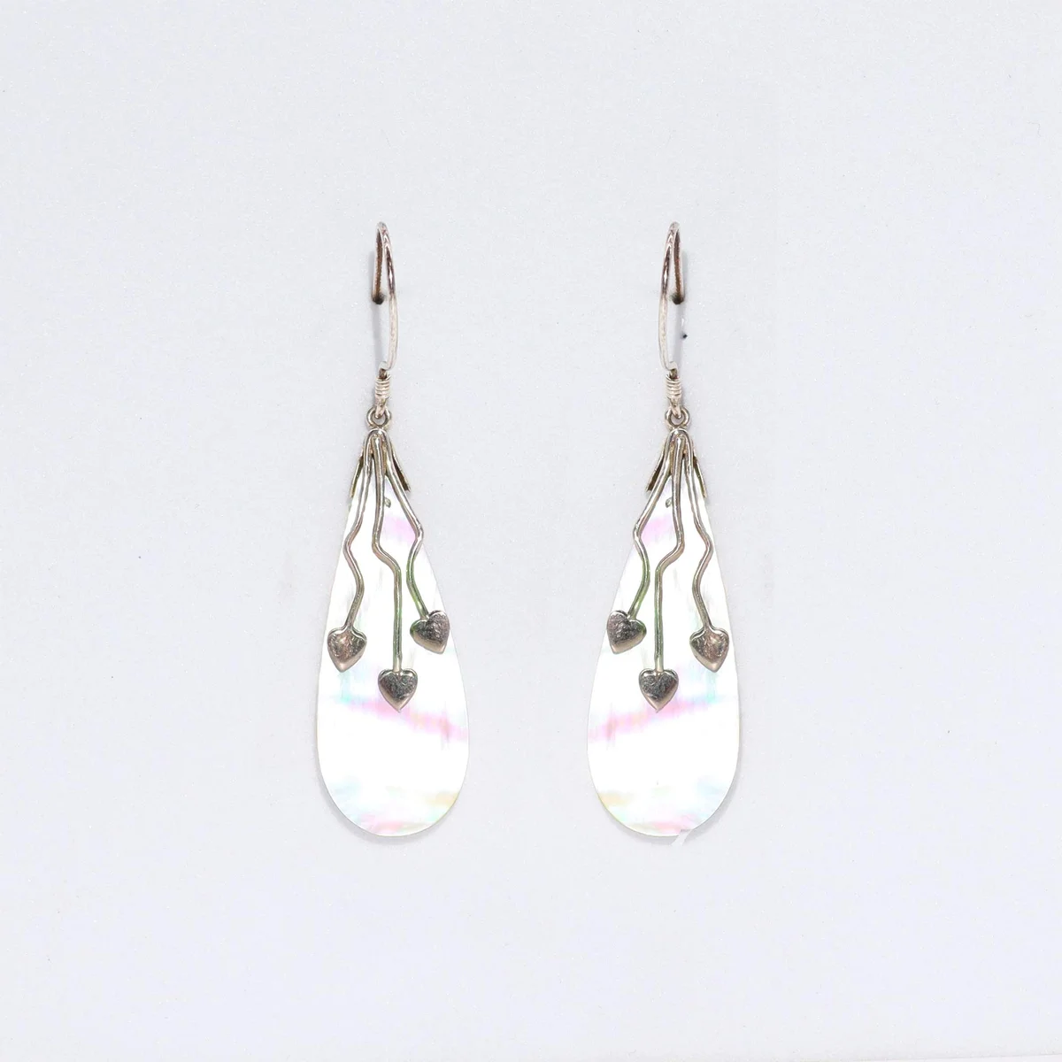 Silver shell earrings with three heart charms displayed together.