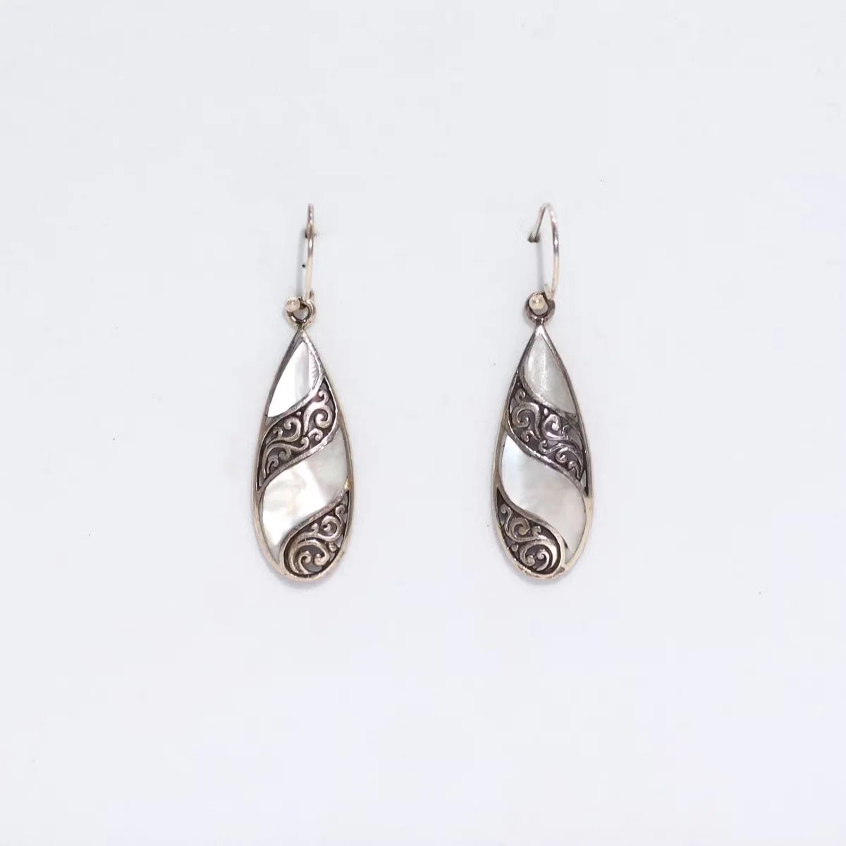 Teardrop shell earrings in silver, showcased on plain backdrop – shell earrings uk