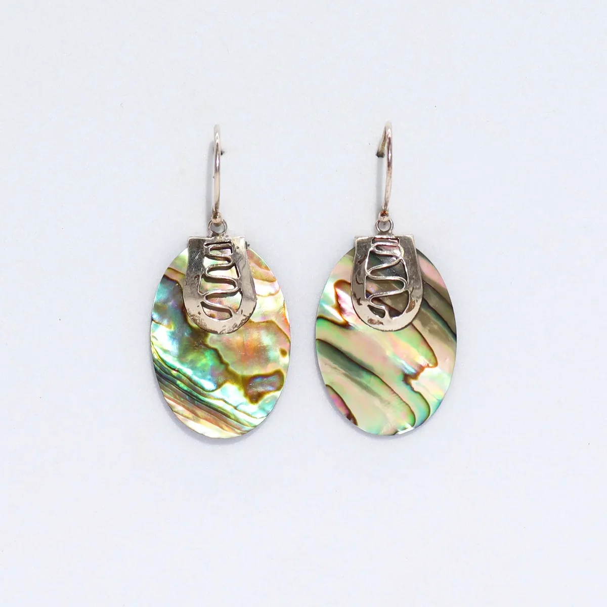 Elegant shell earrings featuring abalone shells with silver accents, displayed as a stylish jewelry pair