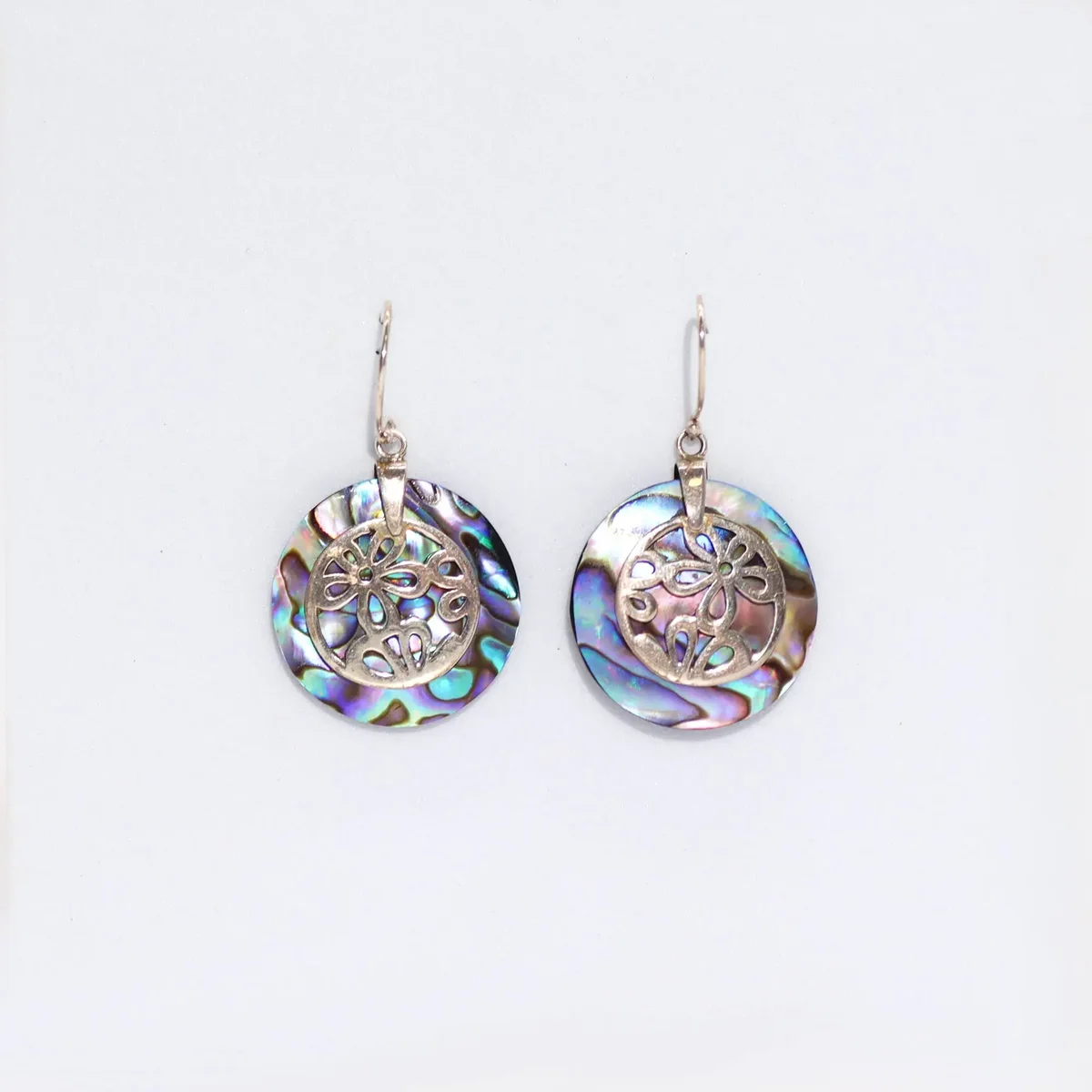 Silver flower earrings featuring delicate abalone shell accents.