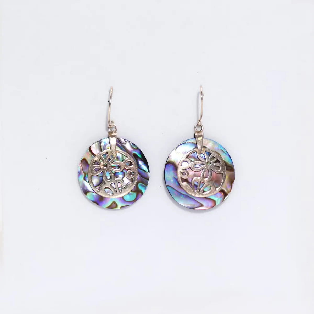 Flower design earrings featuring abalone shells with silver accents.