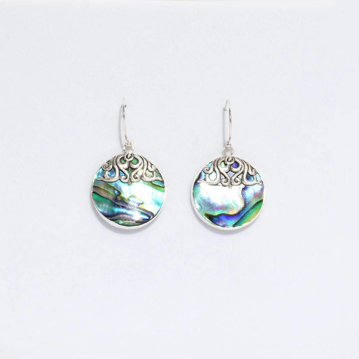 Silver disc earrings showing abalone shell earrings with a glossy finish.