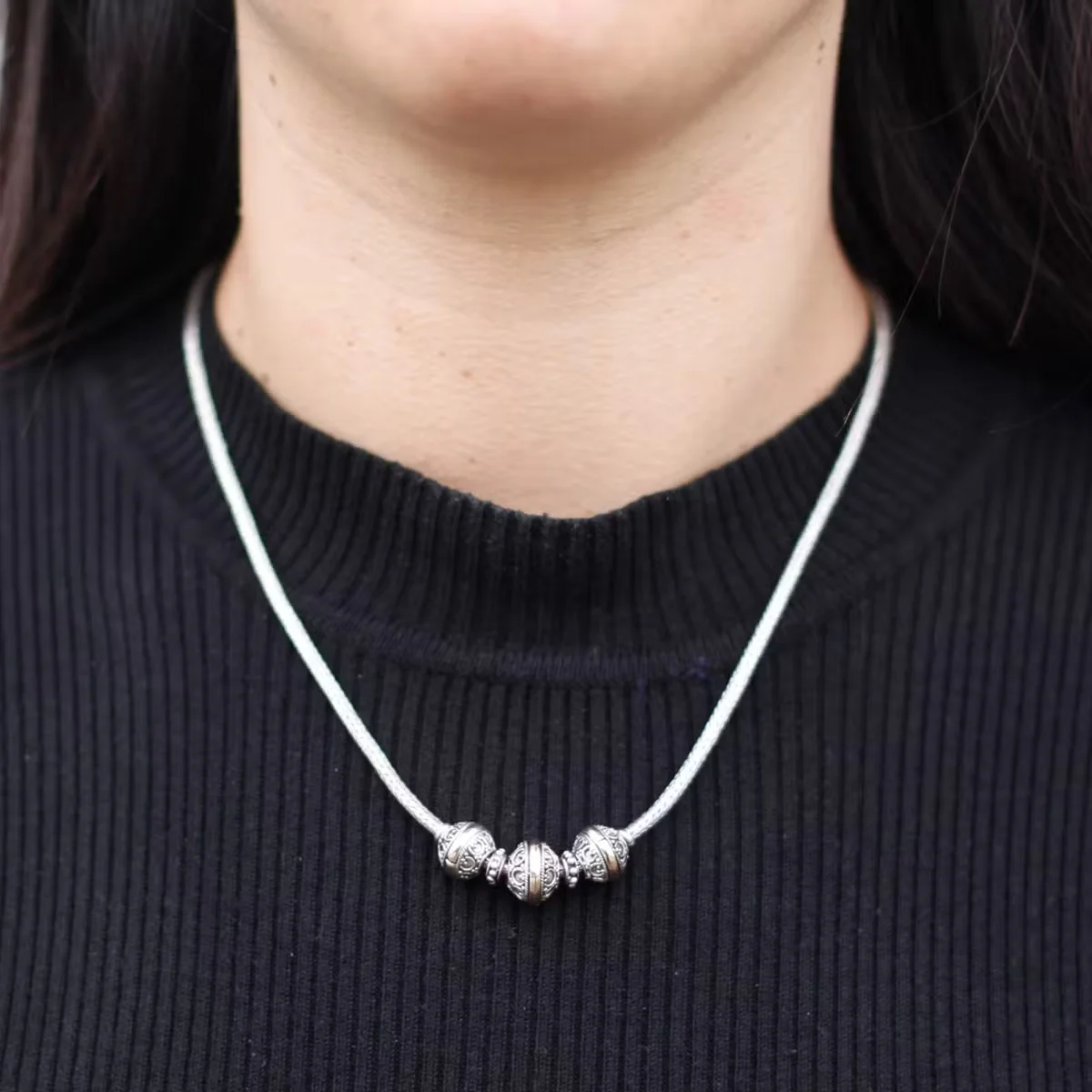 Triangular silver and gold necklace displayed against a white background; classic silver gold jewellery